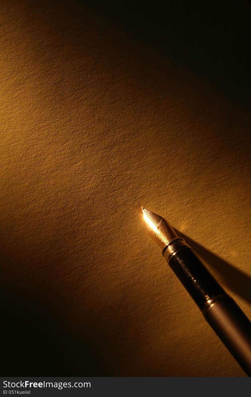 Closeup of stylish ink pen on paper surface with beam of light