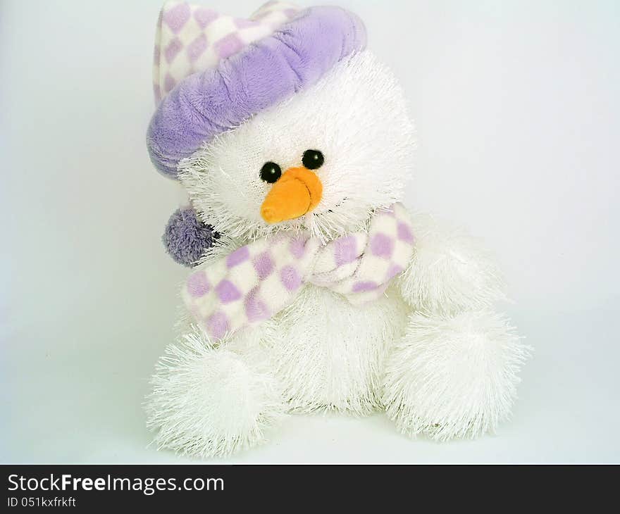 Stuffed snowman plush toy wearing a hat and scarg on a pale gray background