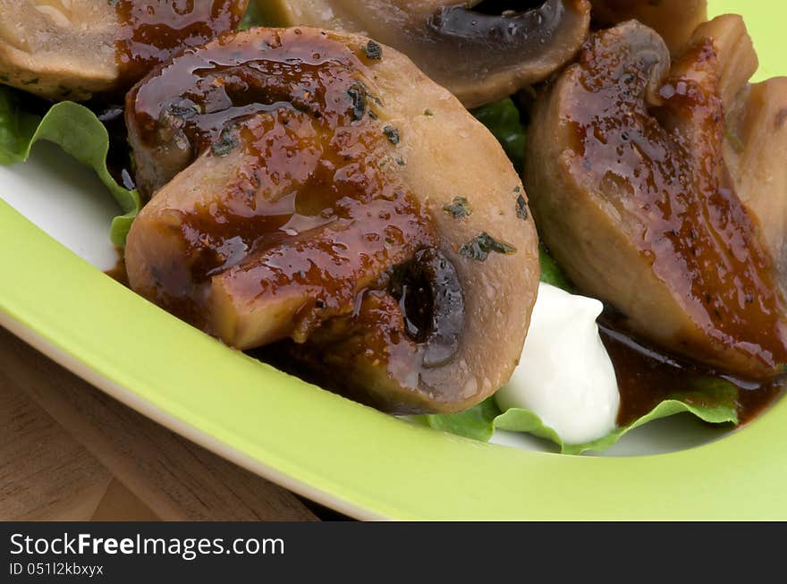 Perfect Roasted Mushrooms Champignons with Grill Sause, Greens and Sour Cream closeup on Green Plate