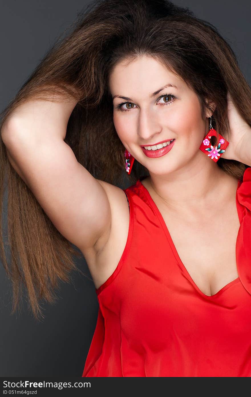 Portrait of a beautiful woman in a red dress and a snow-white smile