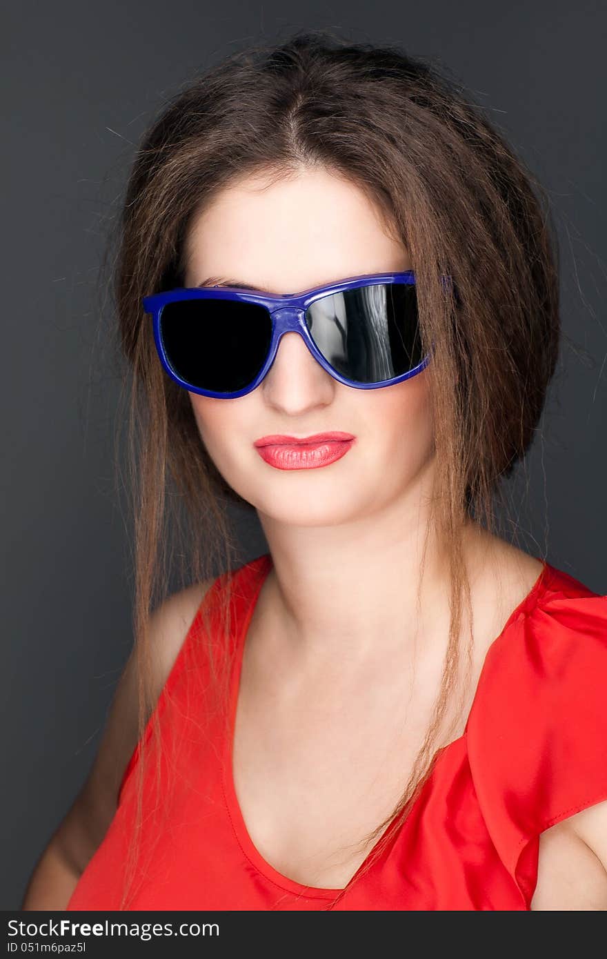 Portrait of a beautiful woman in a red dress and glasses