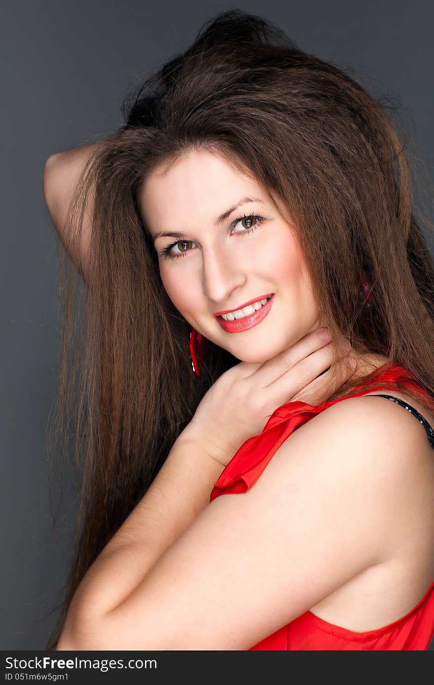 Portrait of a beautiful woman in a red dress and a snow-white smile