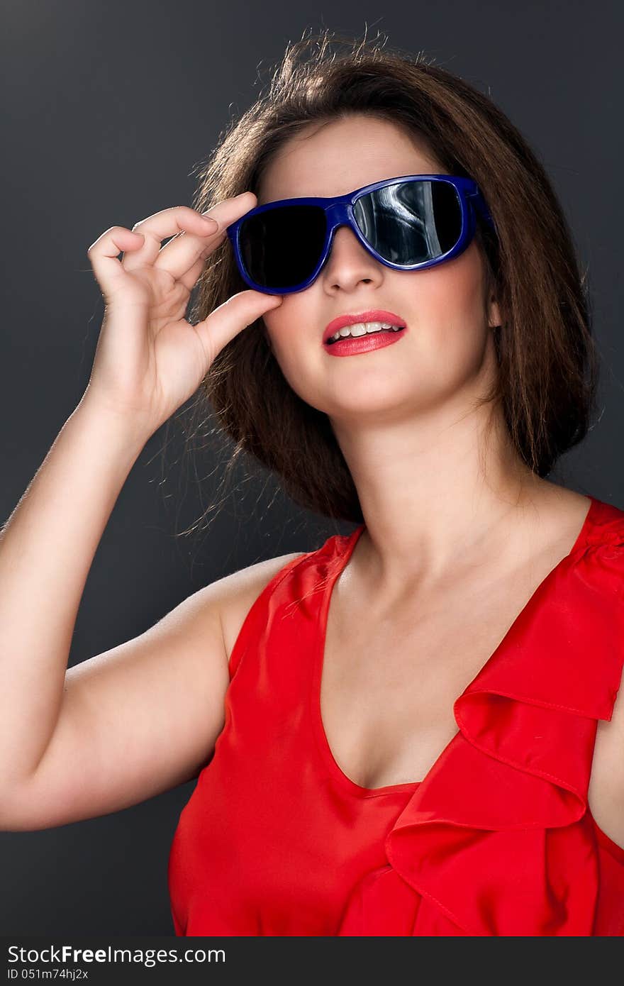 Portrait of a beautiful woman in a red dress, snow-white smile and glasses