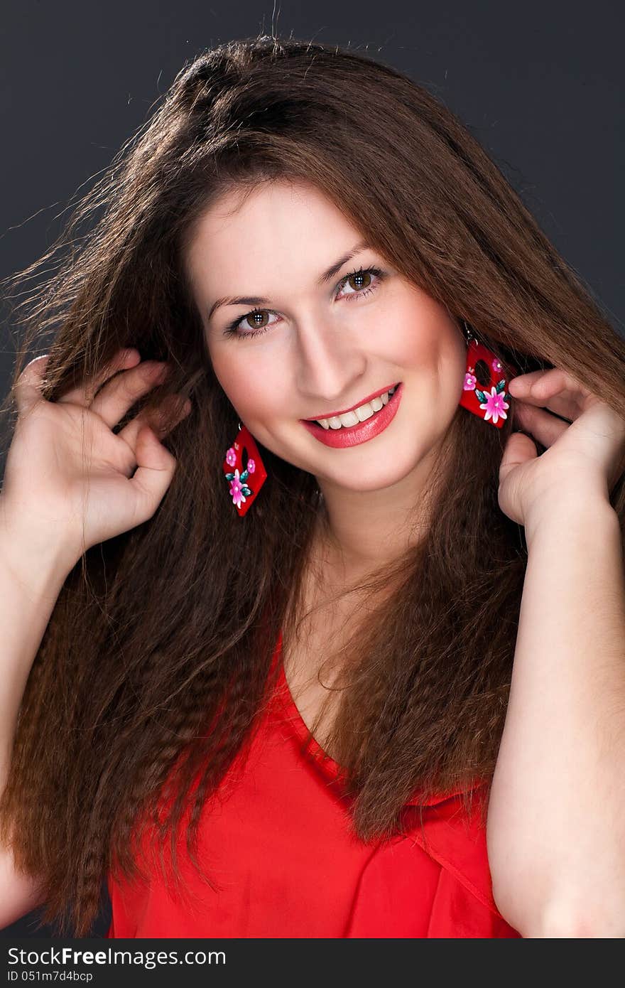 Portrait of a beautiful woman in a red dress and a snow-white smile