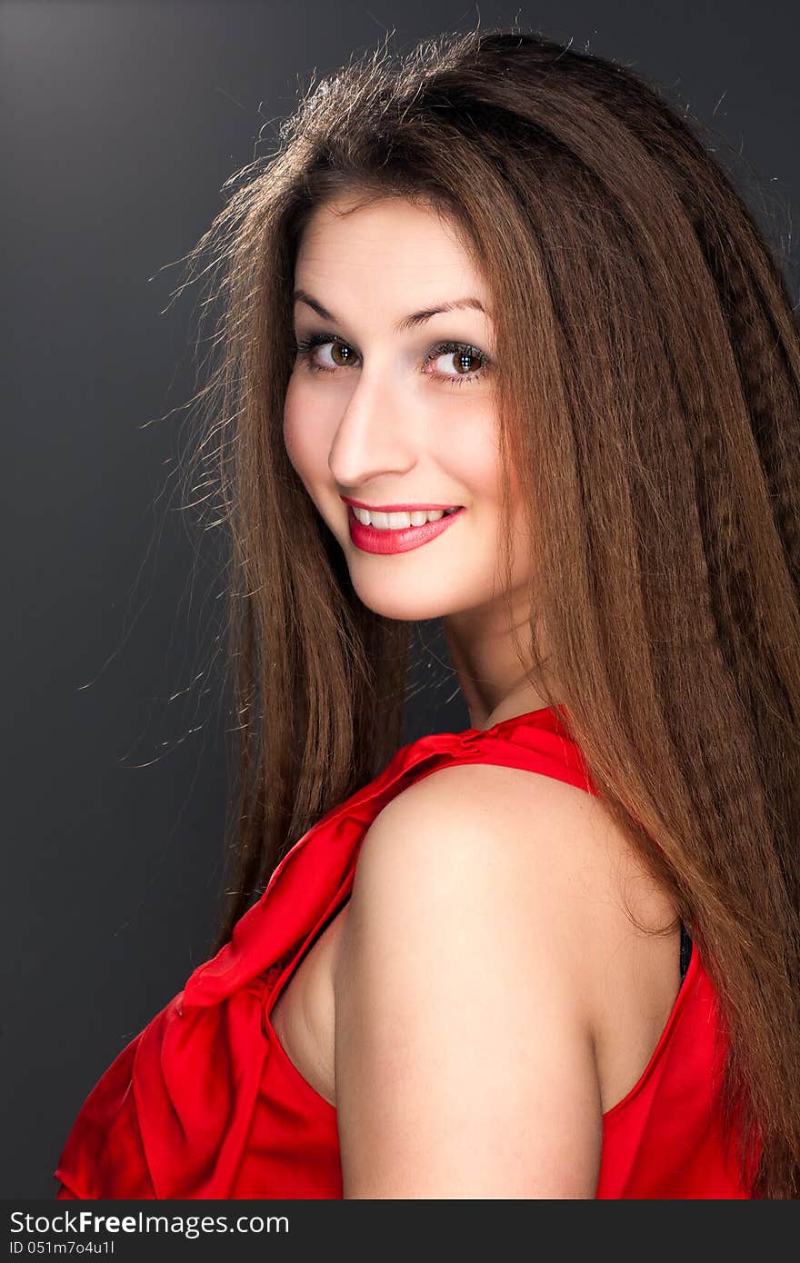 Portrait of a beautiful woman in a red dress and a snow-white smile