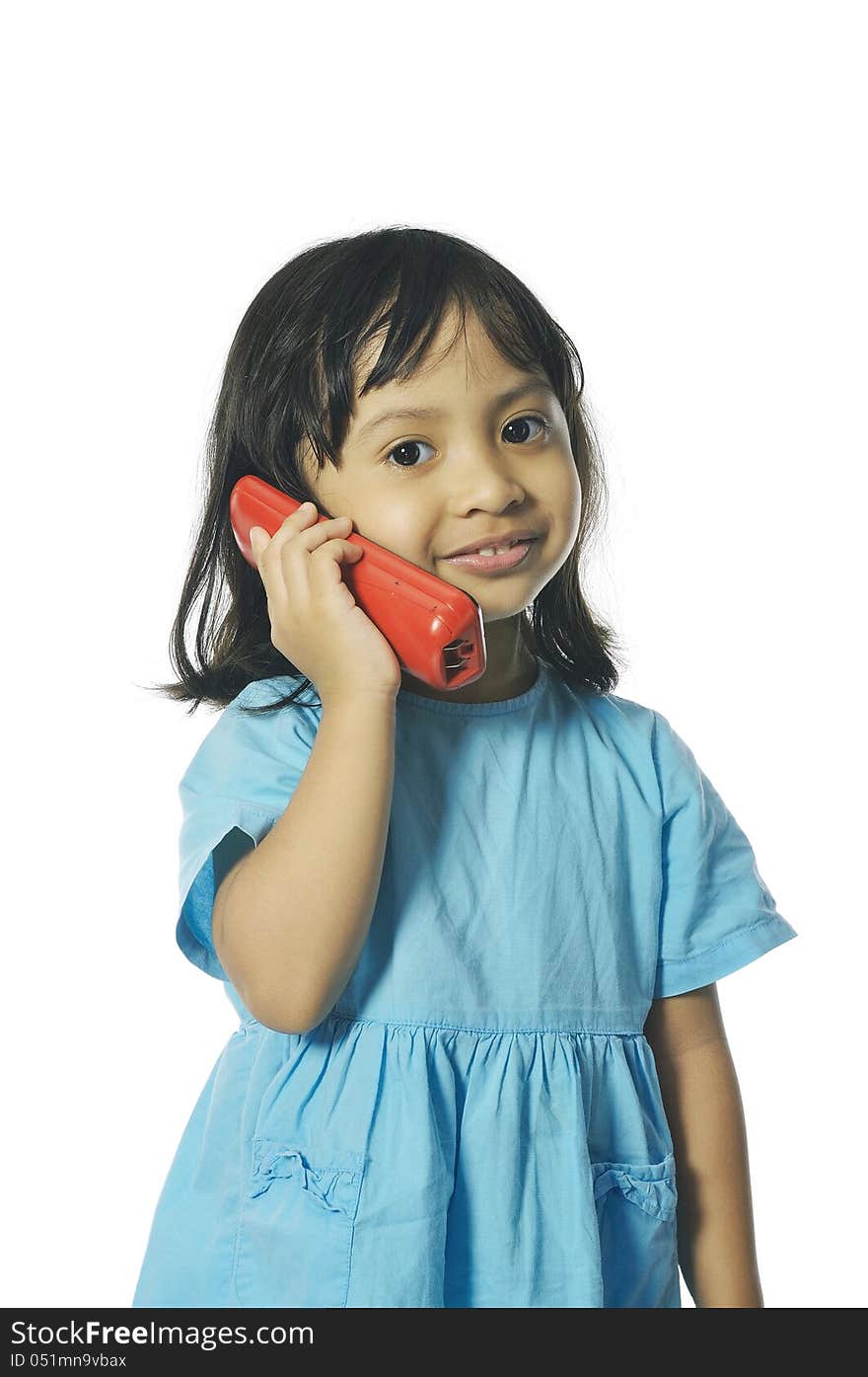 Little girl holding red wireless telephone. Isolated over white background