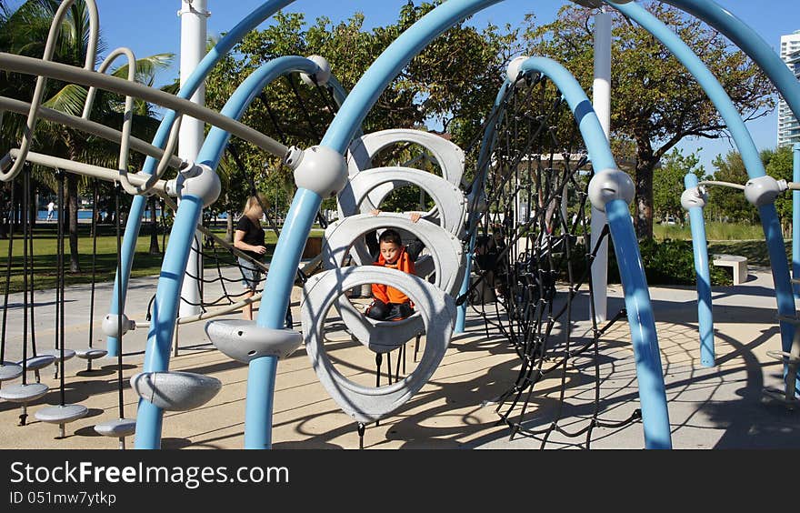 Little boy playing on the playground in South Pointe Park Miami Beach, Florida. Little boy playing on the playground in South Pointe Park Miami Beach, Florida