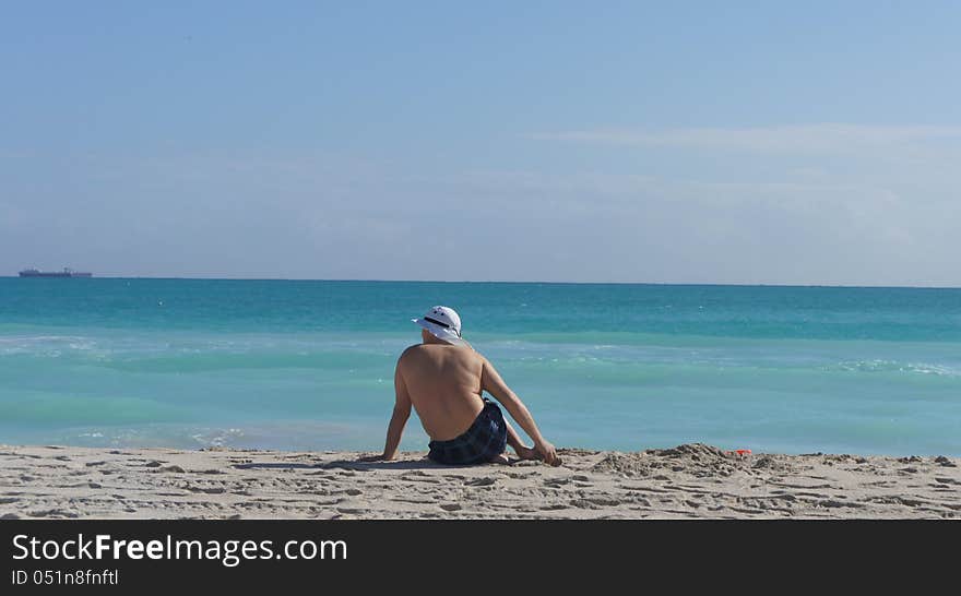 Man Sitting On The Beach