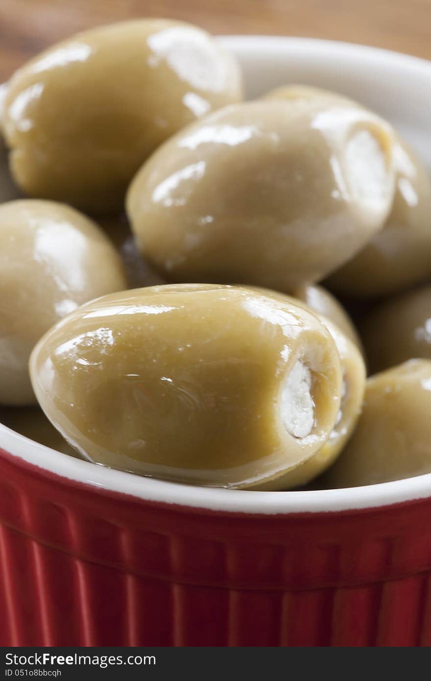 Green olives stuffed with blue cheese in a red and white bowl. Green olives stuffed with blue cheese in a red and white bowl.