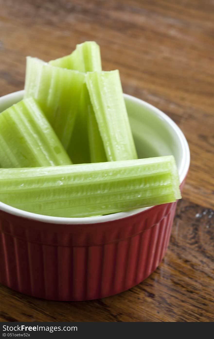 Delicious celery stalks in a red and white bowl.