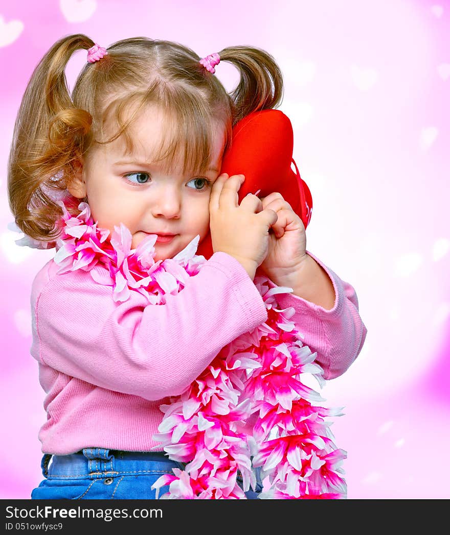 Portrait of a beautiful little girl holding a heart