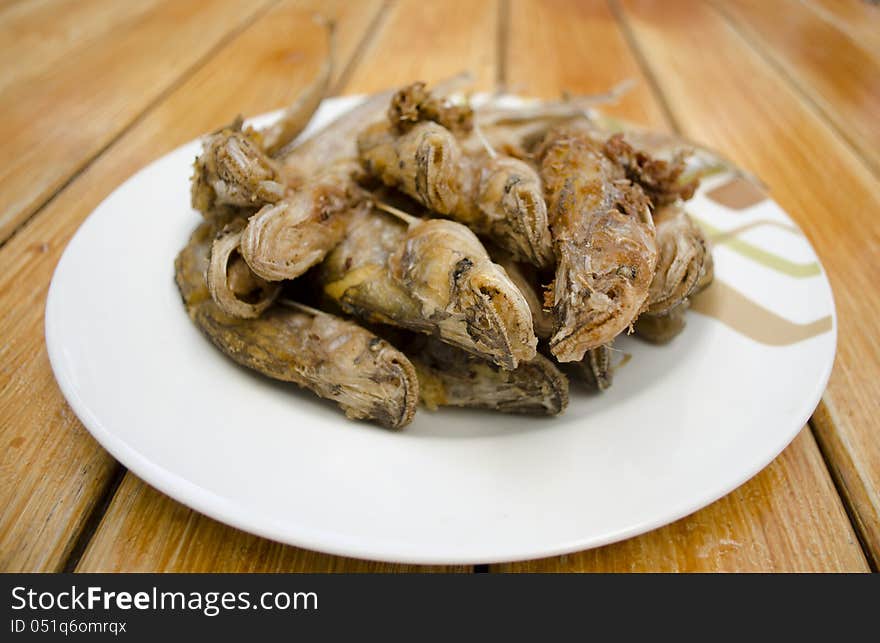 Fried fish on white dish and wood backgroun