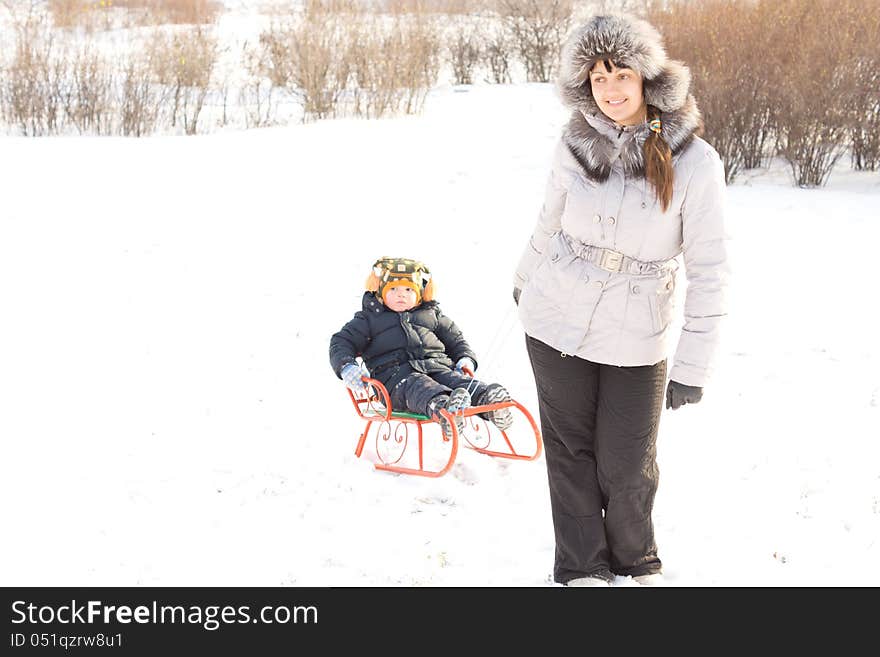 Mother towing her son in the snow