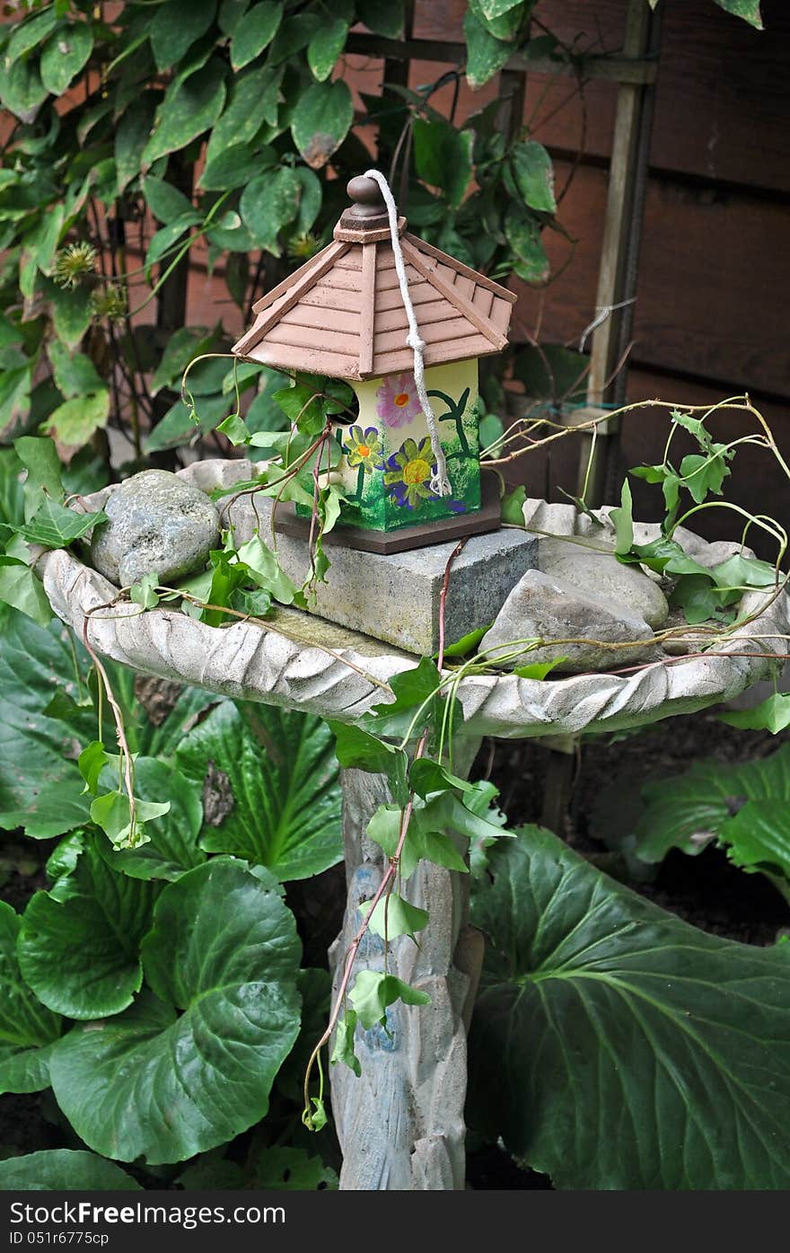 Decorative birdhouse and birdbath in the garden