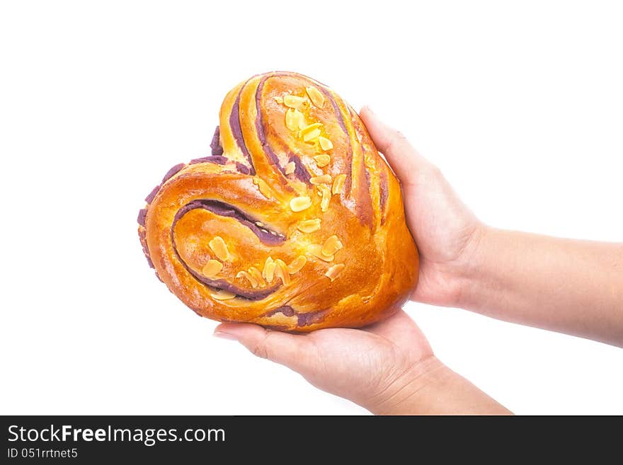 Heart shaped bread with love in hands on white background