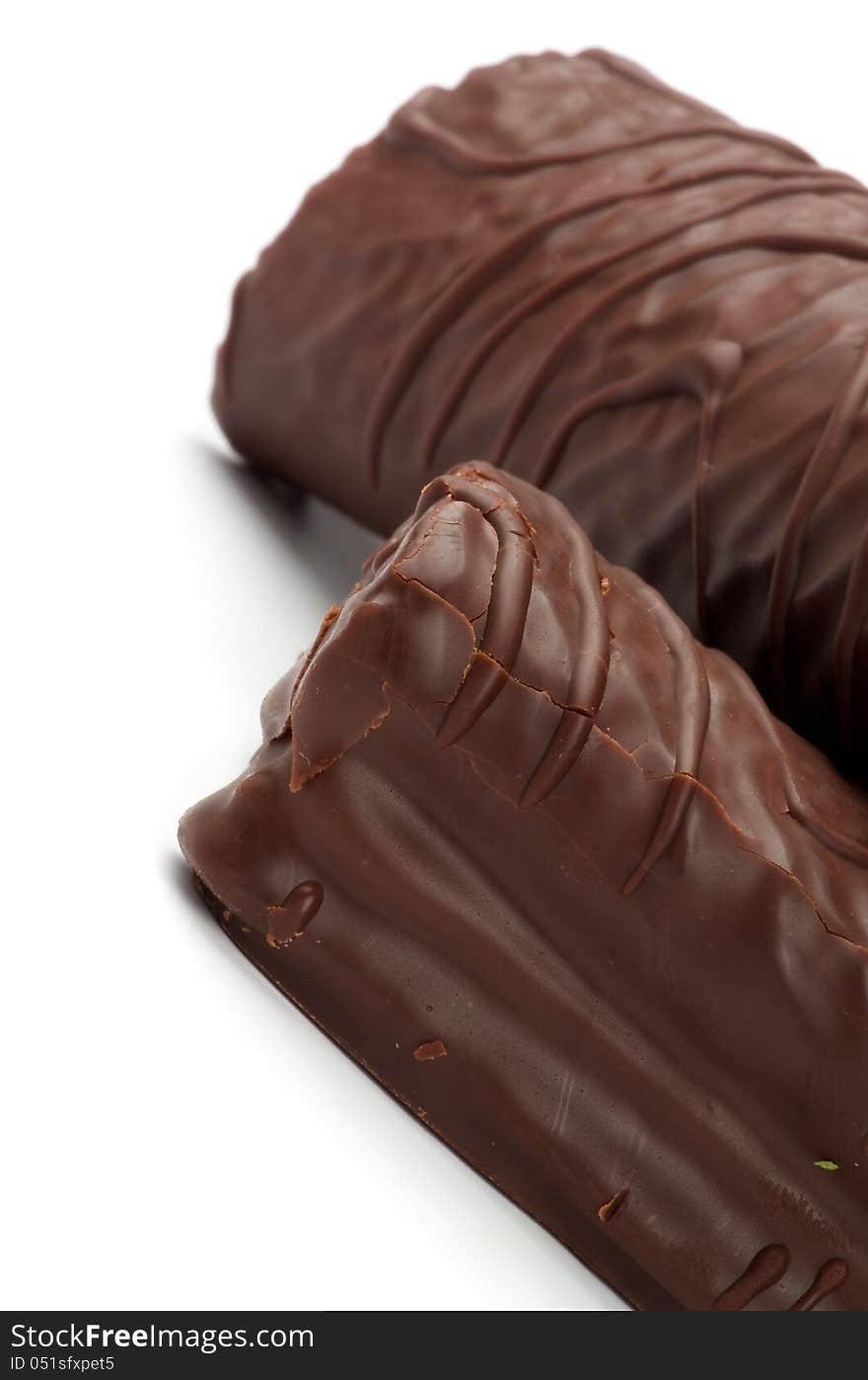 Delicious Biscuit Swiss Rolls with Chocolate Glaze closeup on white background