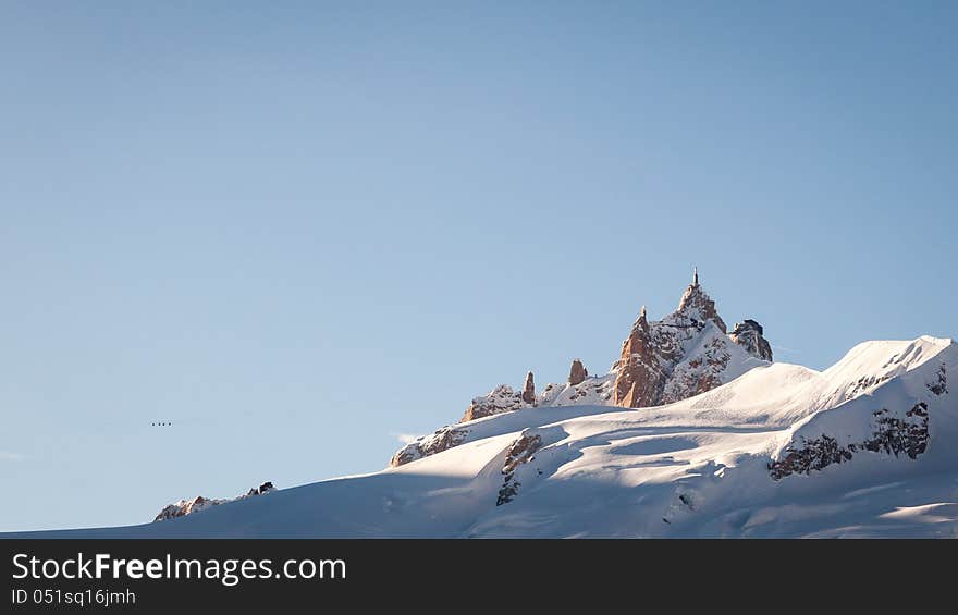 The Aiguille du Midi (3,842 m) is a mountain in the Mont Blanc massif in the French Alps. This was taken from an airplane and shows ski lifts to the mountain top. The Aiguille du Midi (3,842 m) is a mountain in the Mont Blanc massif in the French Alps. This was taken from an airplane and shows ski lifts to the mountain top.