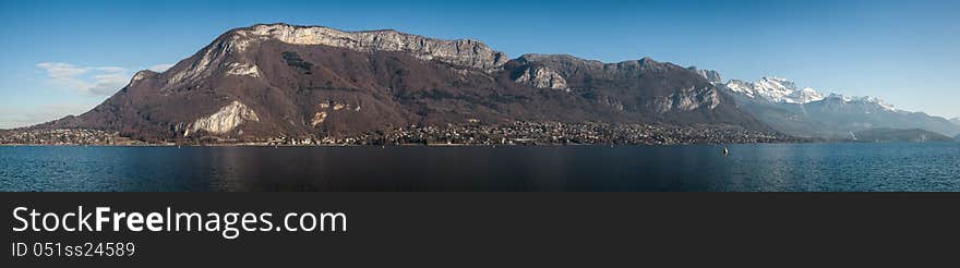 Beautiful panoramic picture of lake Annecy in the French Alps taken on a clear blue sunny and cold winter day. Beautiful panoramic picture of lake Annecy in the French Alps taken on a clear blue sunny and cold winter day.