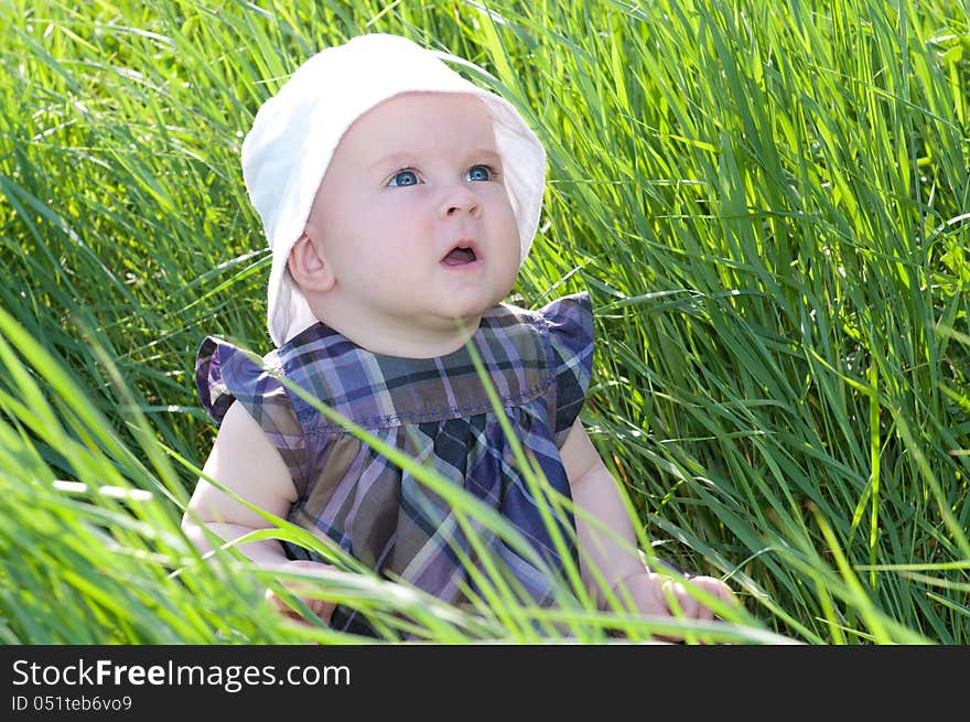 Small child sitting on the green grass. Small child sitting on the green grass