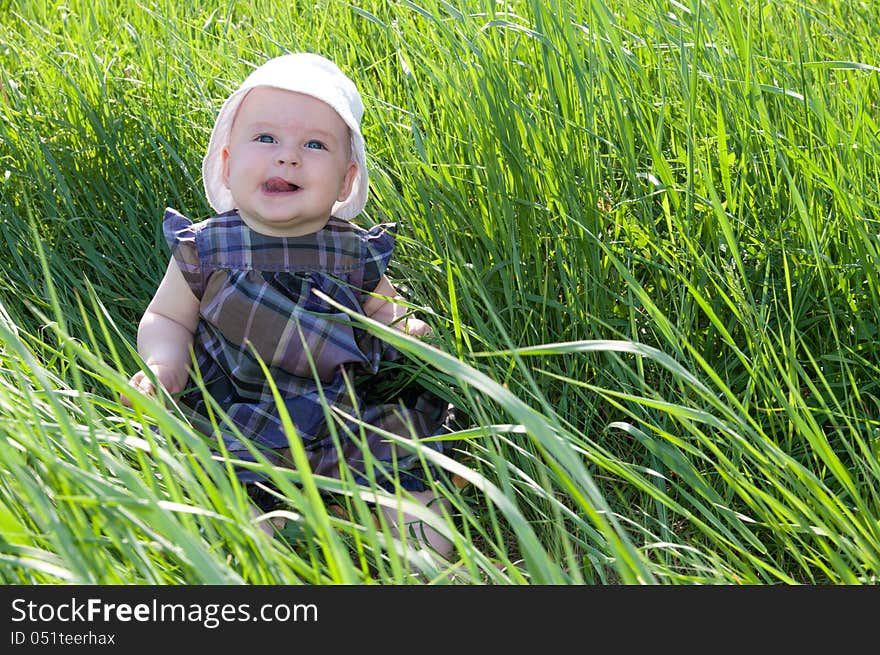 Small child sitting on the green grass. Small child sitting on the green grass