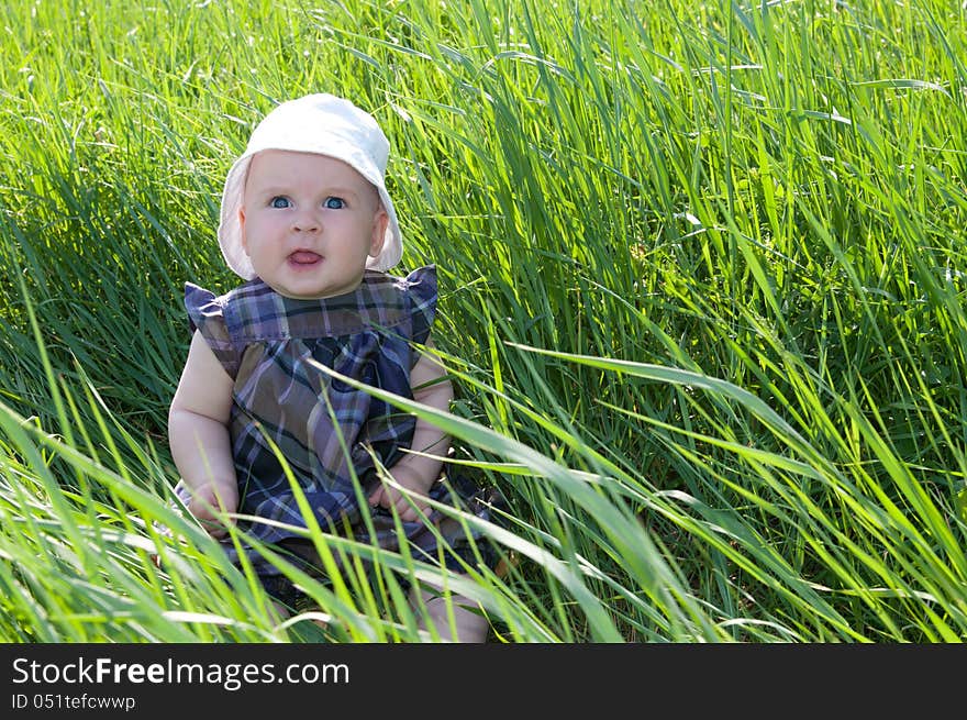 Small child sitting on the green grass. Small child sitting on the green grass