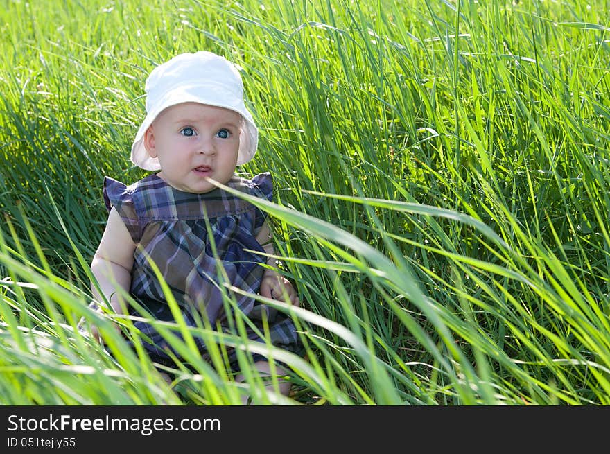 Small child sitting on the green grass. Small child sitting on the green grass