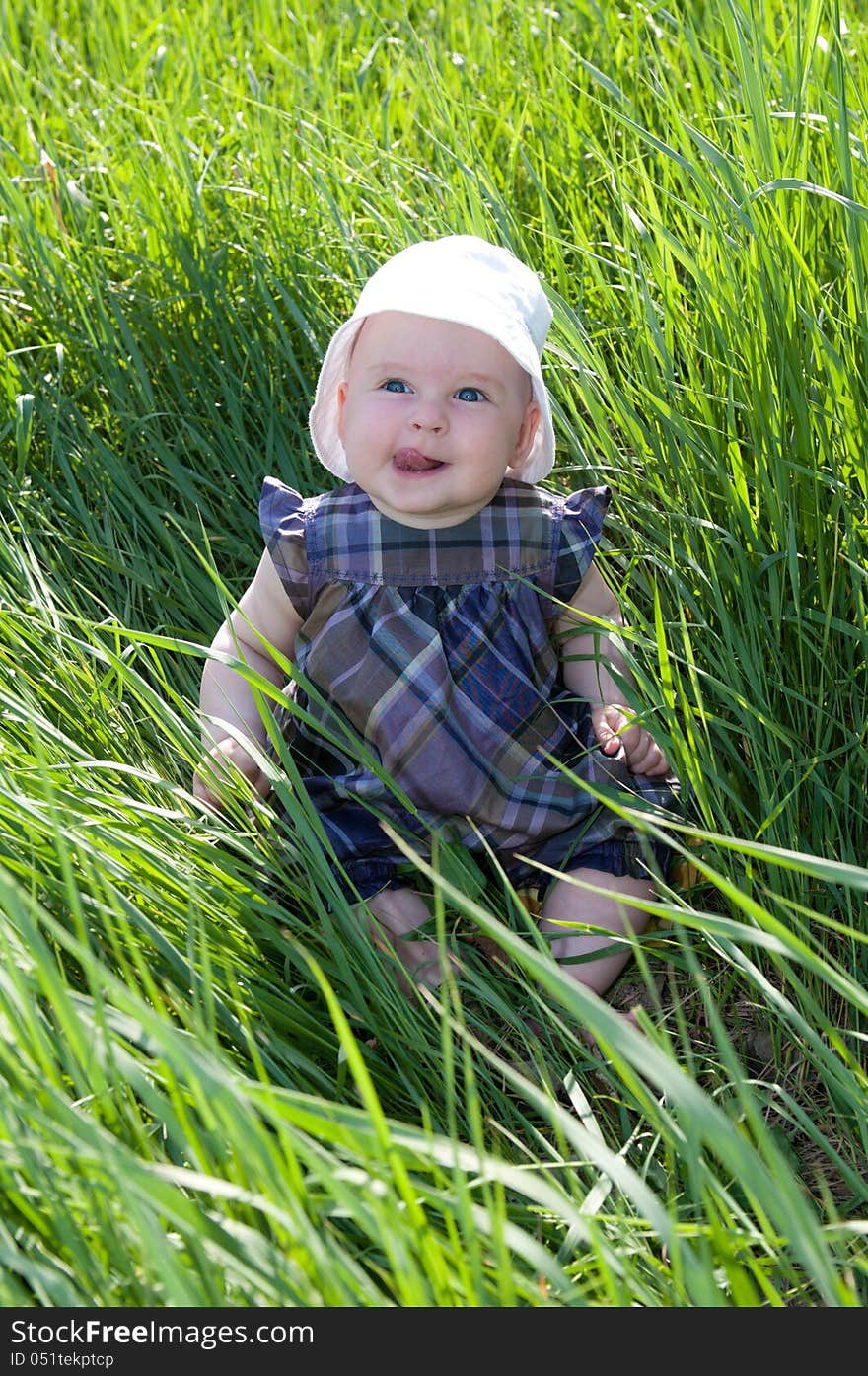 Small child sitting on the green grass. Small child sitting on the green grass