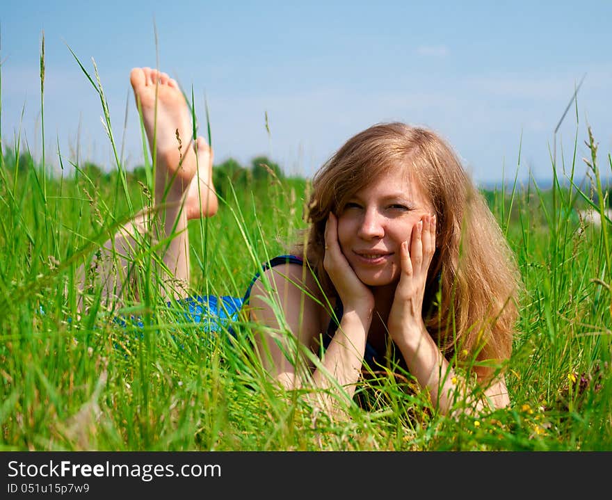 Young woman resting outdoors in meadow. Young woman resting outdoors in meadow