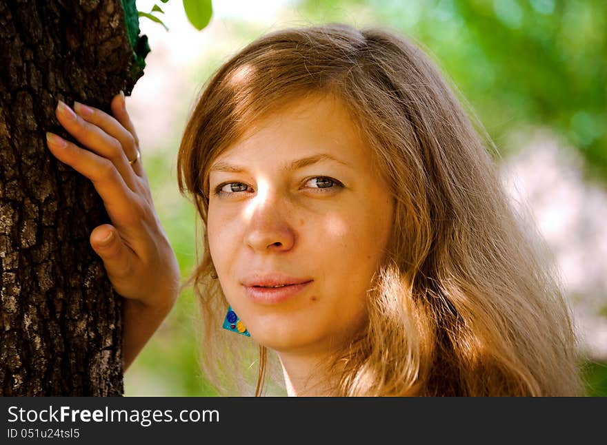 Young woman standing near tree