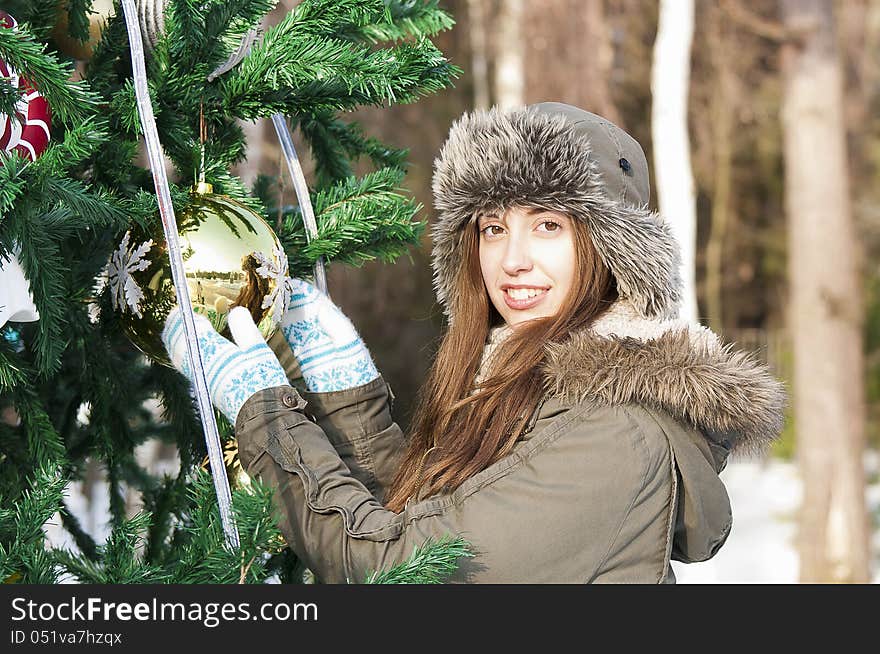 The girl decorates a Christmas tree