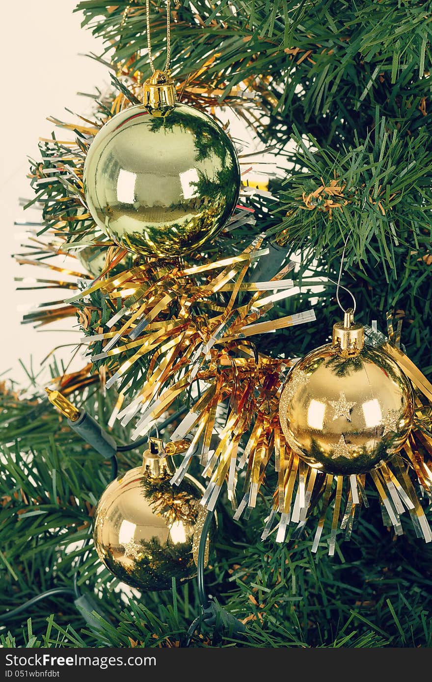 Decorated christmas tree with yellow and green balls on white background