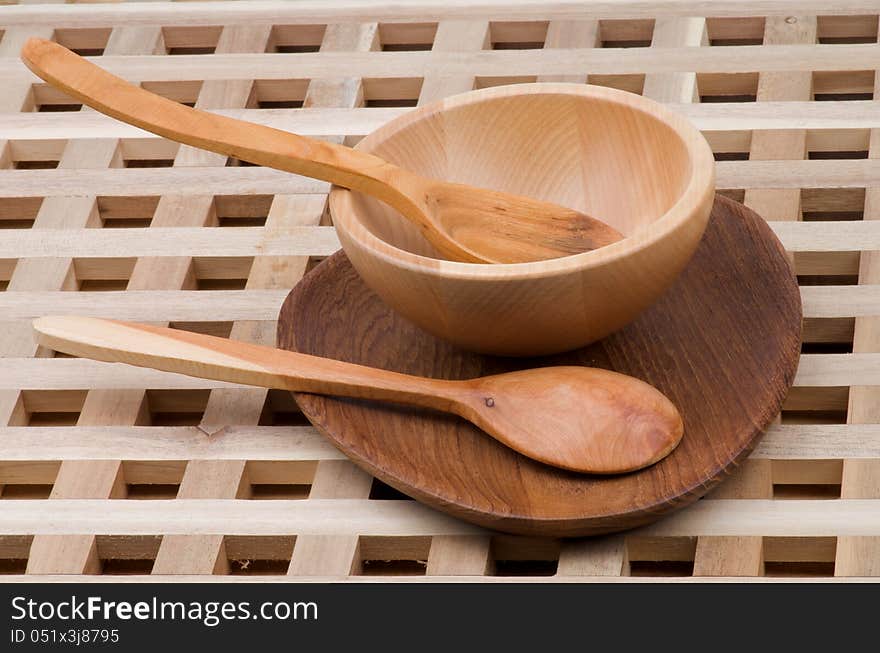 Wood Kitchen Utensil with Spoons, Plate and Bowl closeup on Wooden background