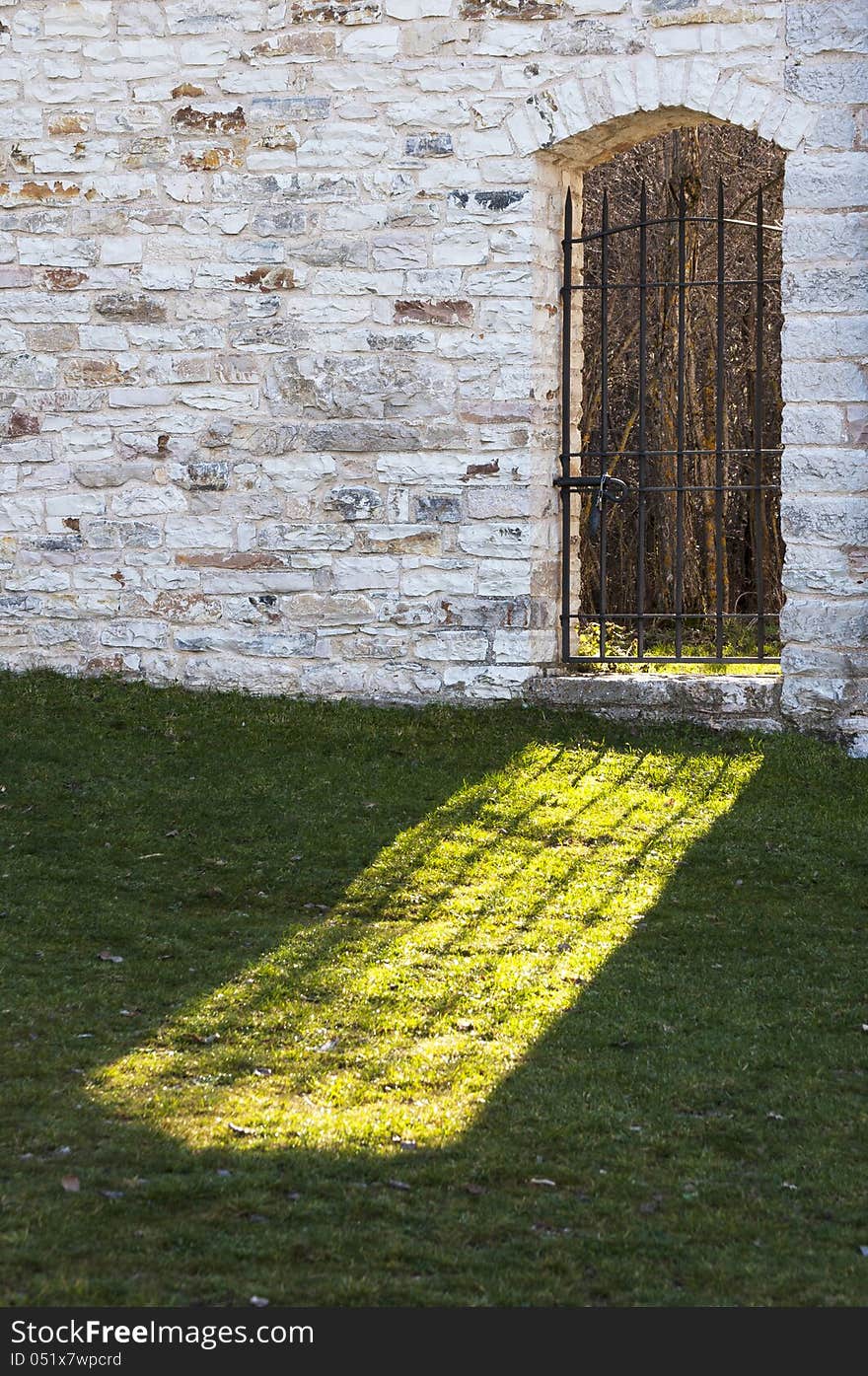 Sunlight pours from the iron gate