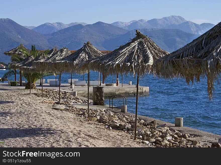 Adriatic coast of Montenegro in the winter. Blue sea and mountains in front resemble us about summer times. Adriatic coast of Montenegro in the winter. Blue sea and mountains in front resemble us about summer times.