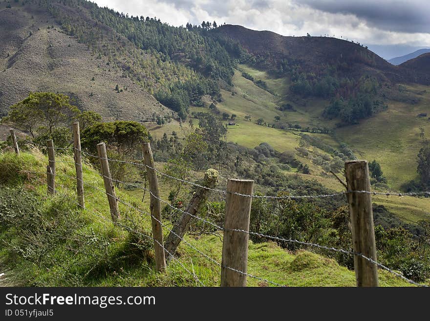 Barbed wire fence in the serria of ecuador with andes mountains in background. Barbed wire fence in the serria of ecuador with andes mountains in background