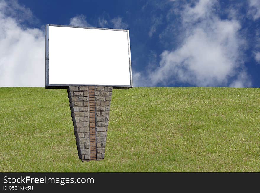 Blank signpost in the grassland over blue sky.