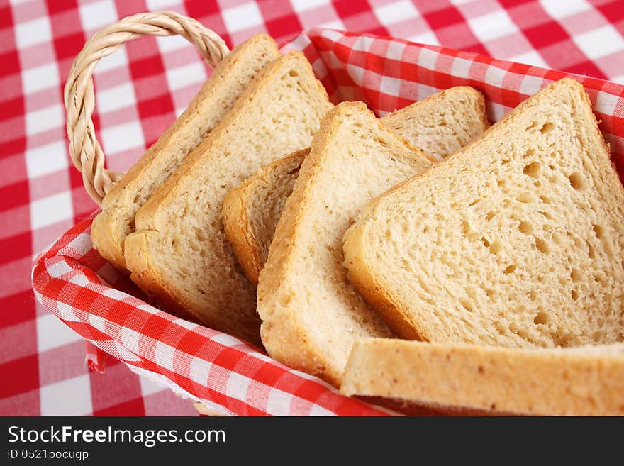 Sliced bread in a basked , red and white check background