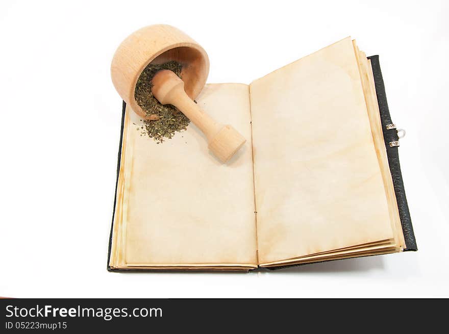 Mortar with herbs on the book. Mortar with herbs on the book