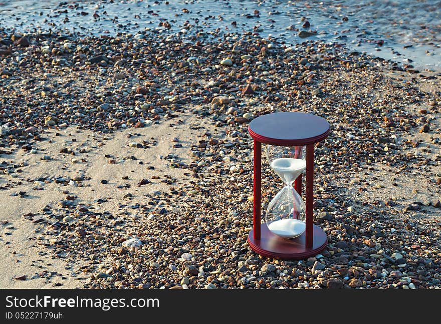 Hourglass on a beach  symbolizing vulnerability of marine ecology systems. Hourglass on a beach  symbolizing vulnerability of marine ecology systems