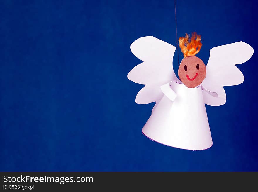 Cheerful boy paper angel on a blue background. Cheerful boy paper angel on a blue background