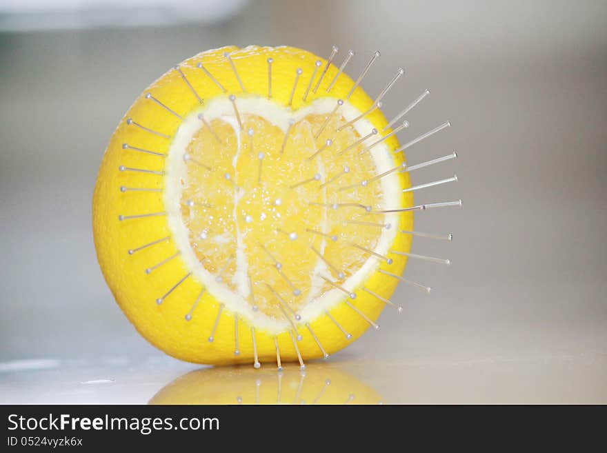 Love hurts concept with an orange fruit and pins