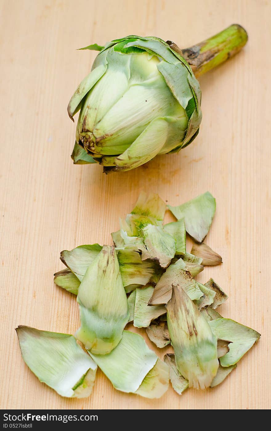 Removing dry leaves from a globe artichoke. Removing dry leaves from a globe artichoke