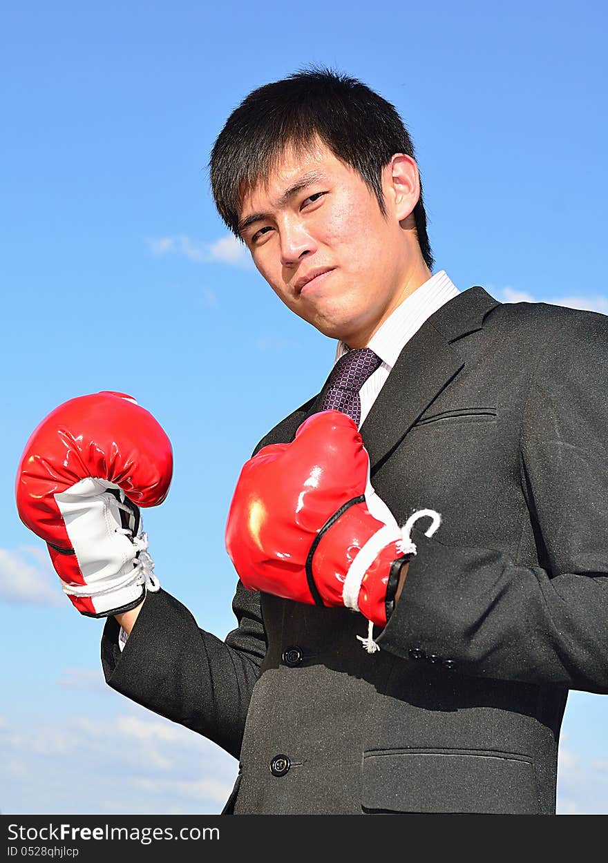 Close up businessman and hand boxing glove ready to fight over blue sky. Close up businessman and hand boxing glove ready to fight over blue sky.