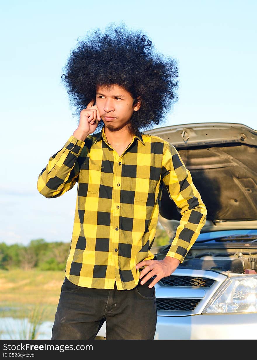 Close up of Long-haired young man on the cellphone for help