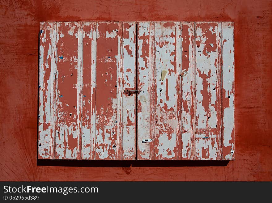 Old window with the orange wooden shutters