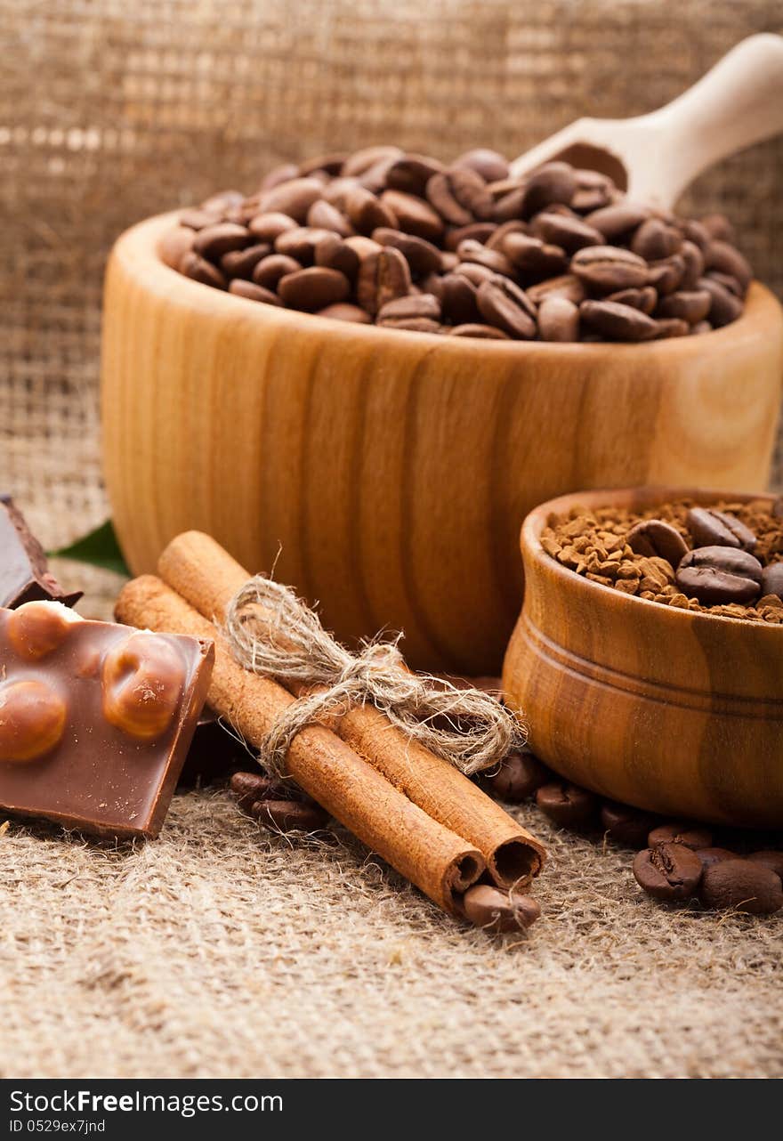 Coffee beans in a wooden bowl on burlap background