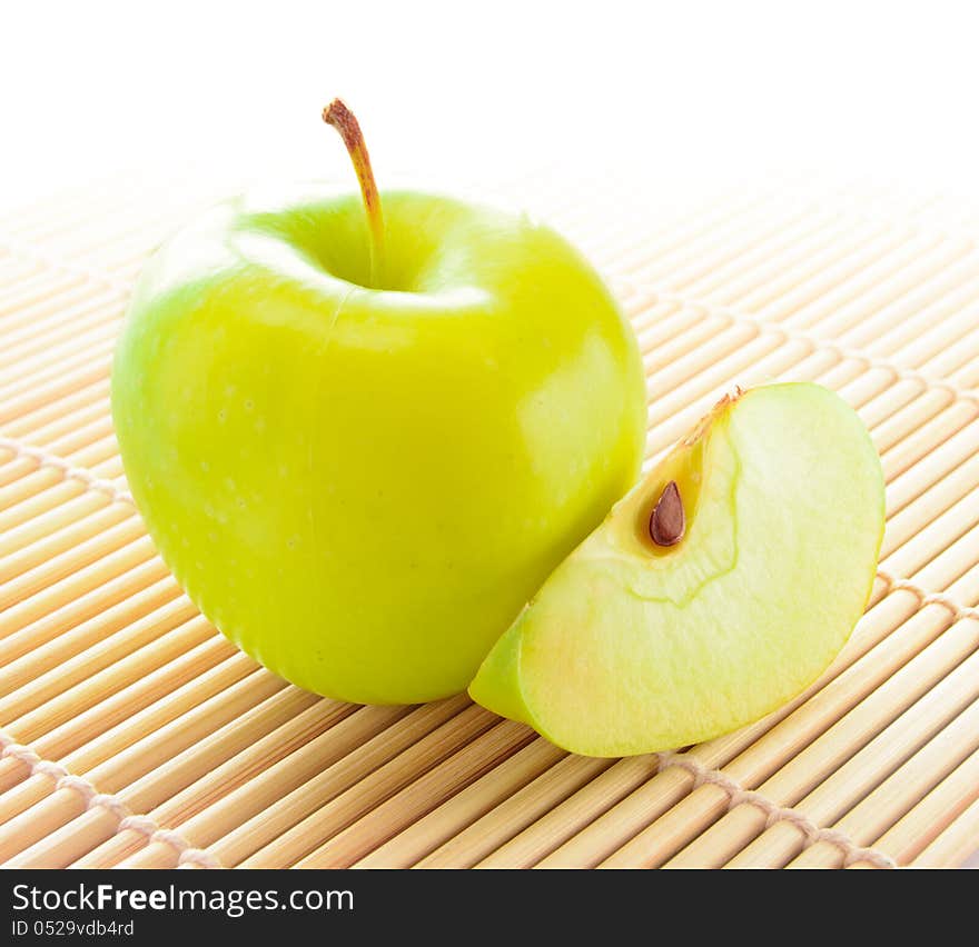 Yellow Apple with Apple Slice on the Bamboo Mat