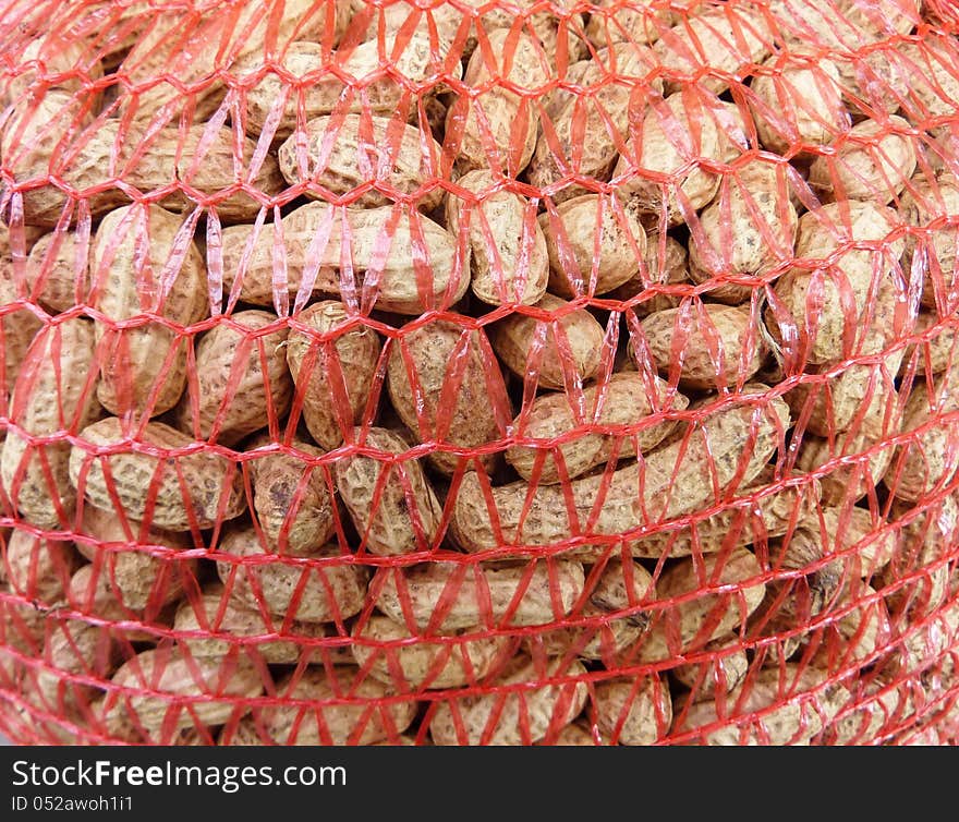 Enpeeled peanuts in a net. Enpeeled peanuts in a net