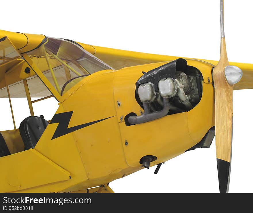 Front close-up of a yellow vintage high wing small aircraft, showing the engine cylinders, propeller, and front cockpit. Isolated on white. Front close-up of a yellow vintage high wing small aircraft, showing the engine cylinders, propeller, and front cockpit. Isolated on white.