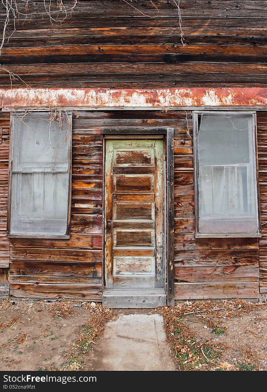 A frontal view of an old grocery store door and windows. A frontal view of an old grocery store door and windows.